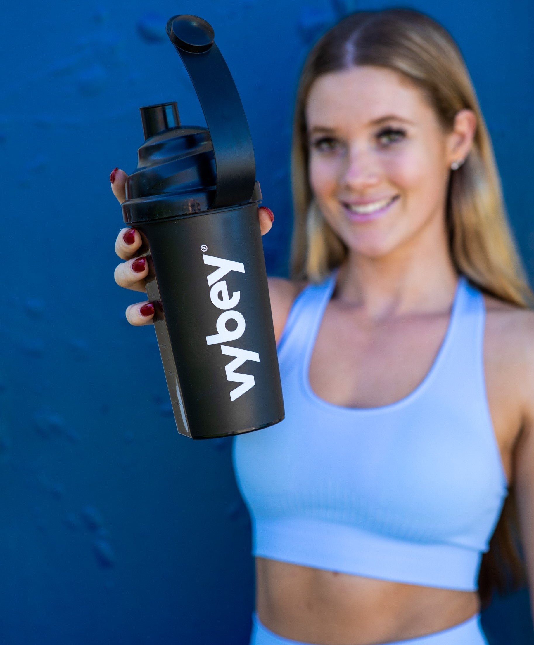 picture of madi holding vybey's meal replacement shaker bottle which is used to shake complete meal powder